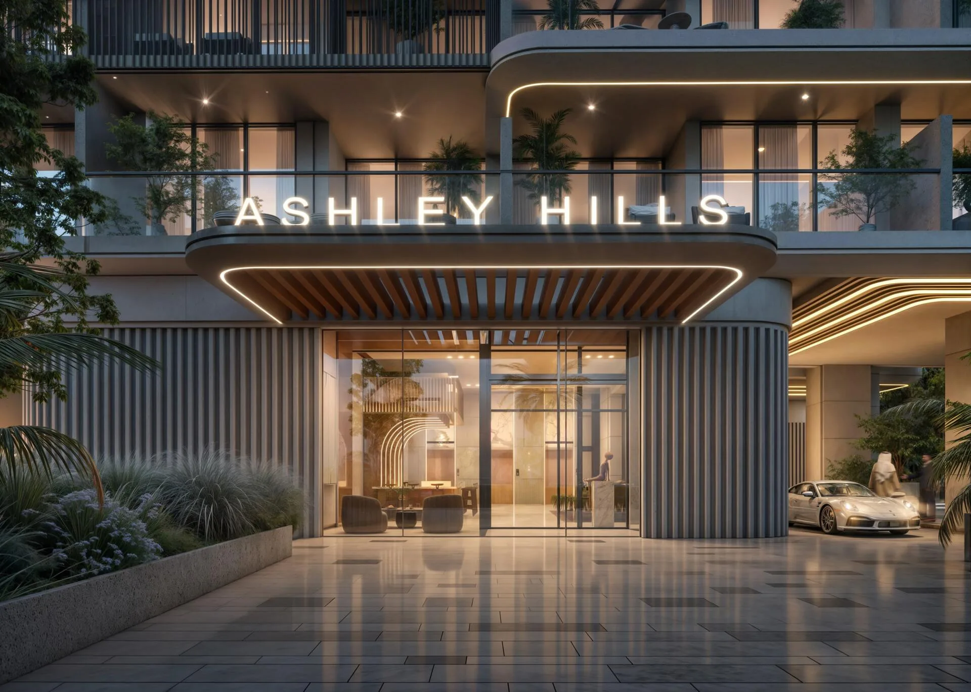 Парадный вход Ashley Hills вечером: подсвеченный козырёк и стеклянные двери лобби
