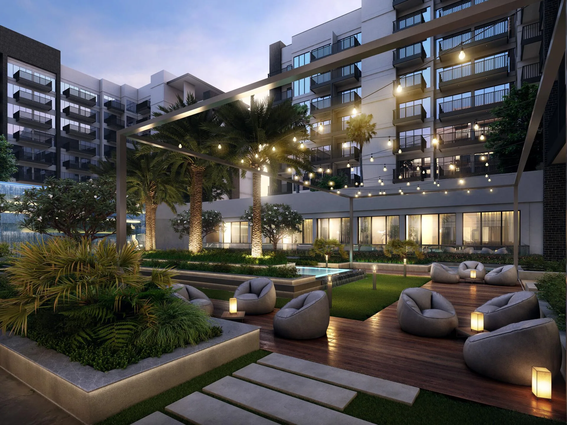 Кресла на деревянном настиле под гирляндами во дворе Beach Oasis
