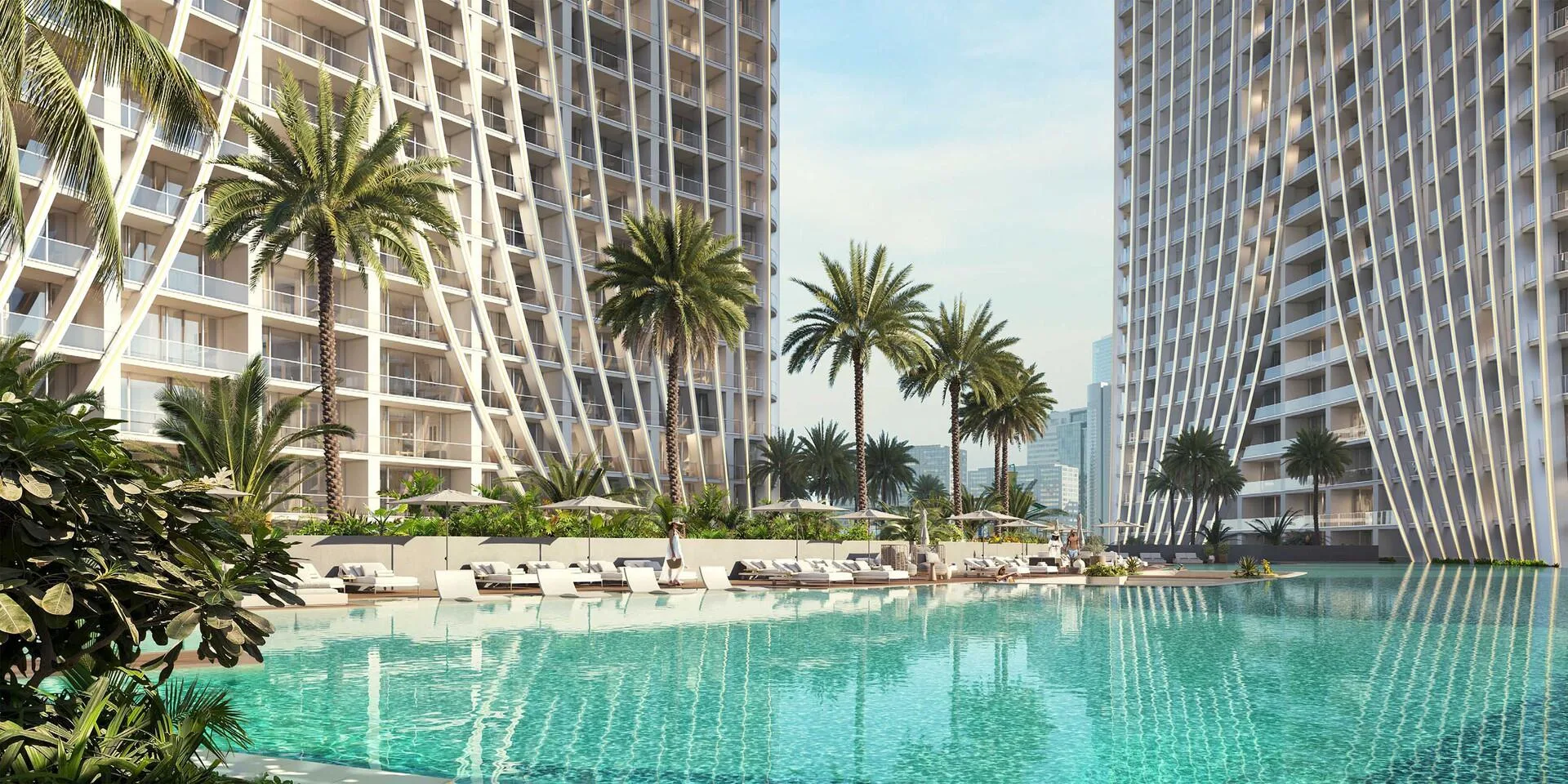 Бассейн с шезлонгами и пальмами у подножия башен Binghatti Skyrise