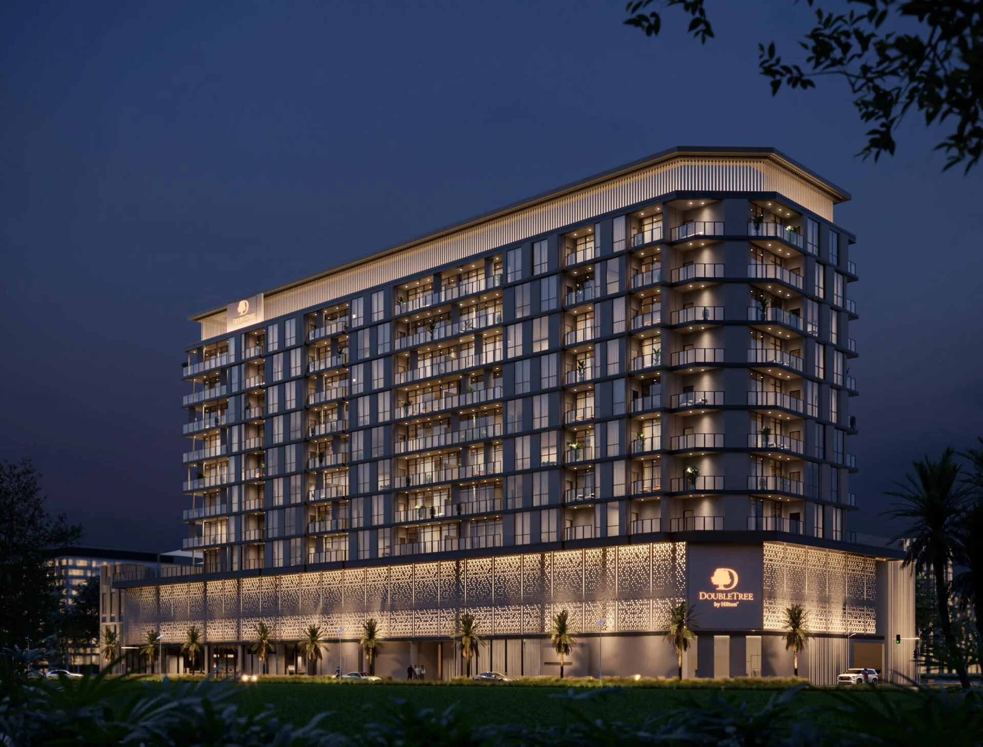 DoubleTree by Hilton Residences ночью: подсвеченный фасад и знак на основании