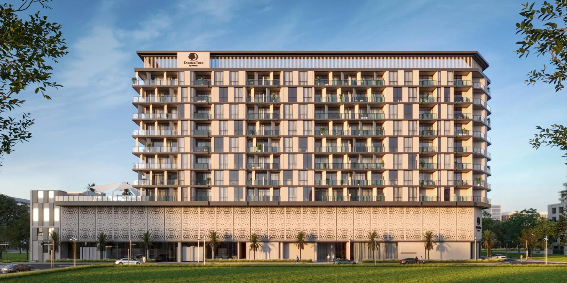 Фасад DoubleTree by Hilton Residences днём: балконы, резной экран основания и газон перед домом