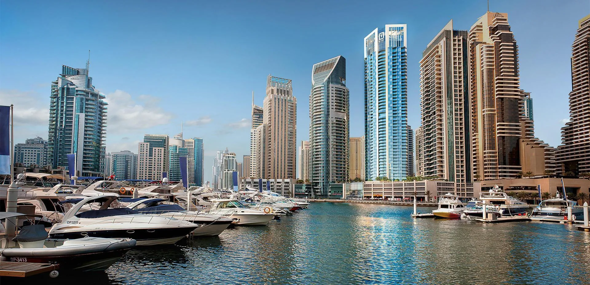 Dubai Marina днём: яхты у причалов и башня LIV Marina среди небоскрёбов