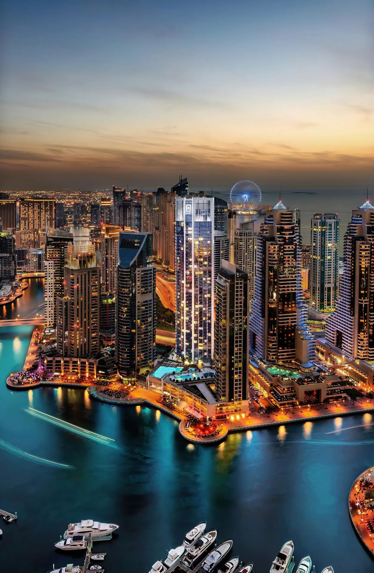 Dubai Marina ночью с высоты: башня LIV Marina у воды, вдали море и колесо обозрения