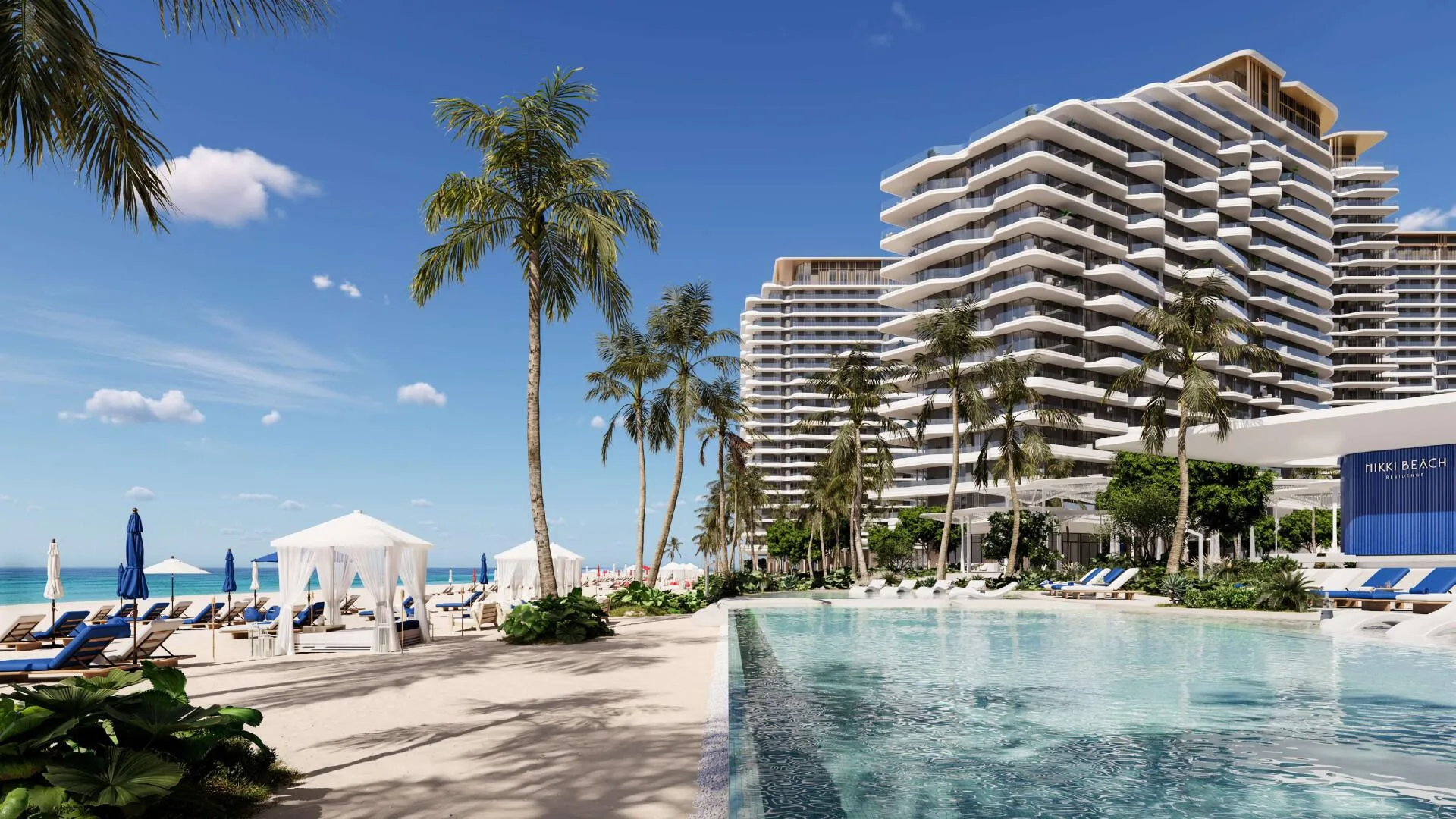 Бассейн с шезлонгами у моря и башни Nikki Beach Residences