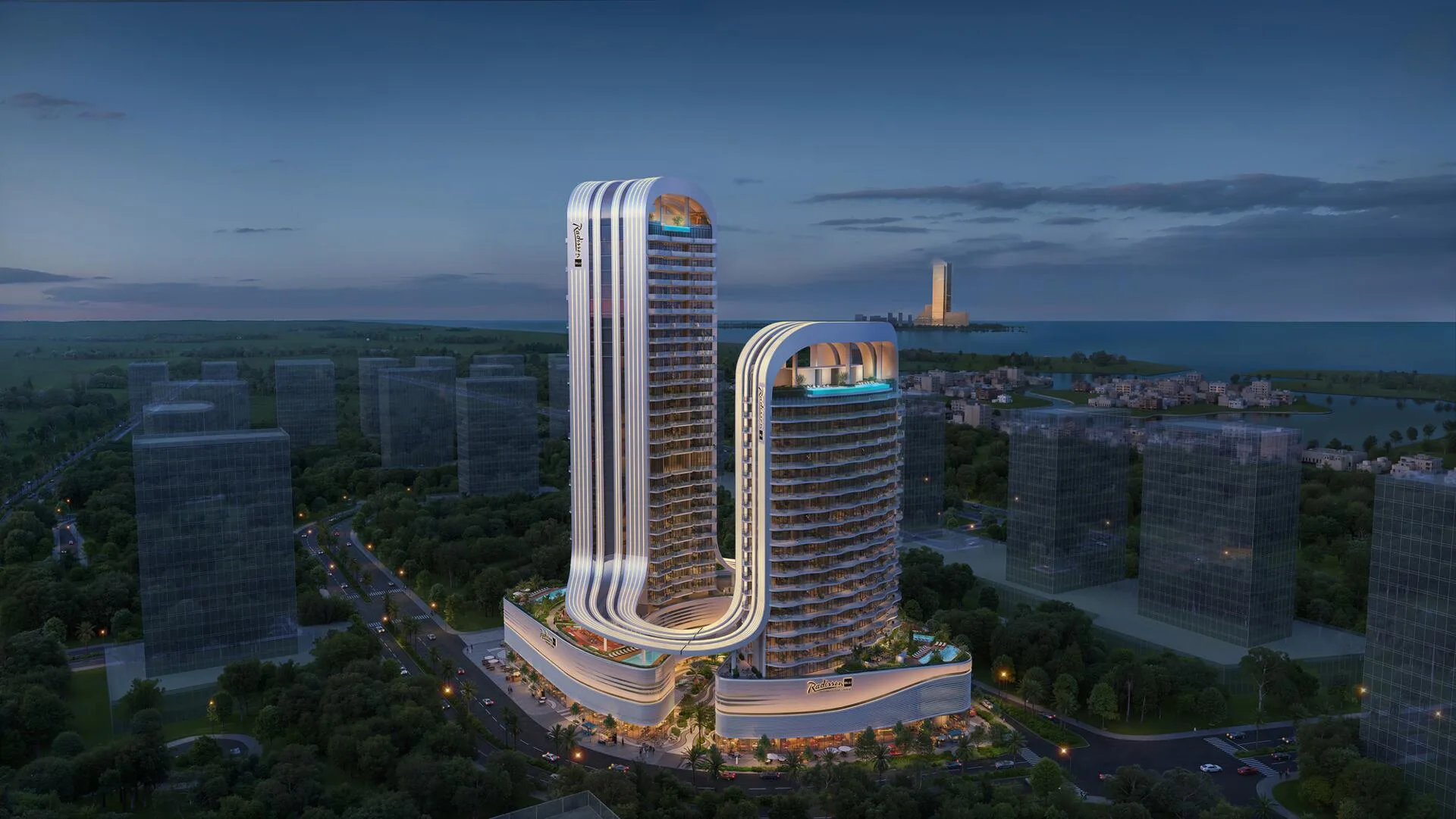 Башни Radisson Blu RAK Central вечером, за ними море