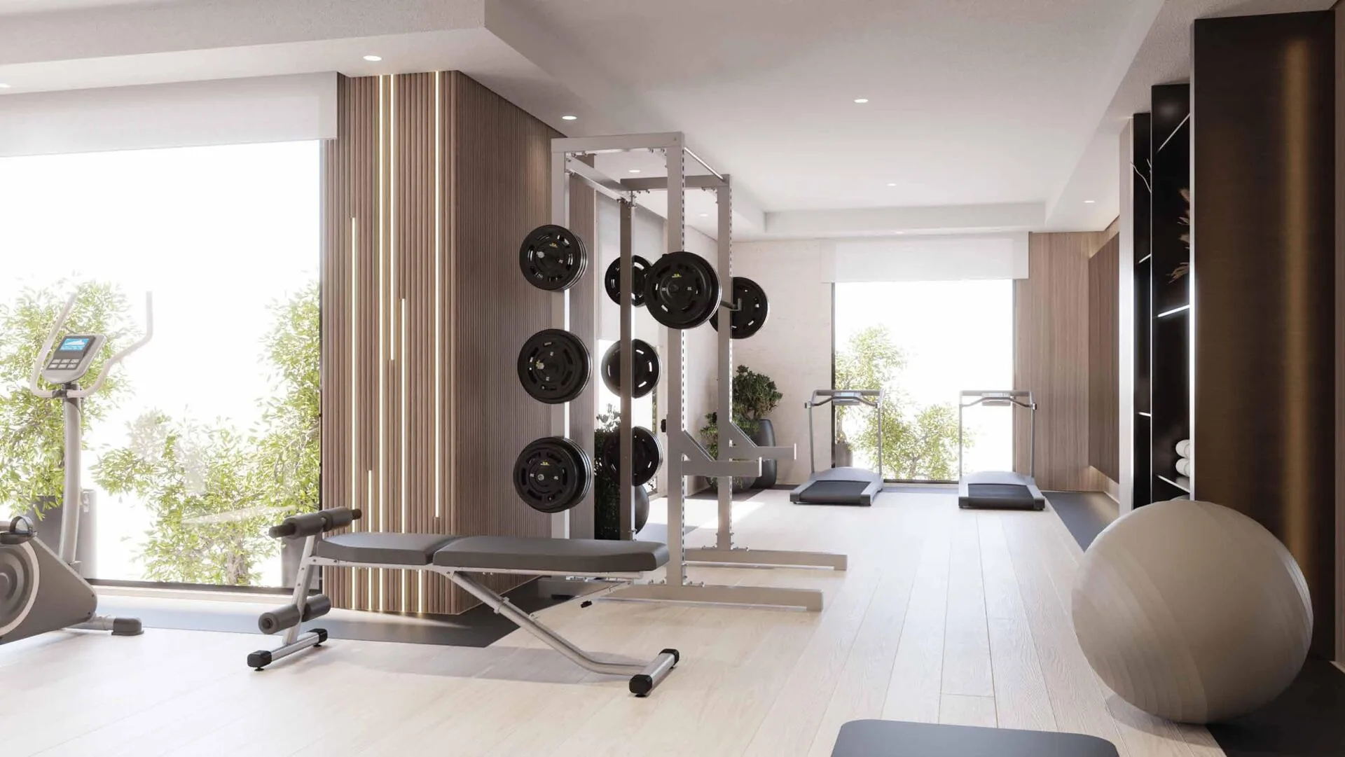 Тренажёрный зал Riva Residence: силовая рама, беговые дорожки и окна в зелень