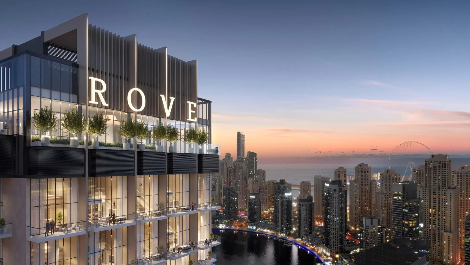 Верх башни Rove Home с буквами ROVE на закате, внизу канал марины