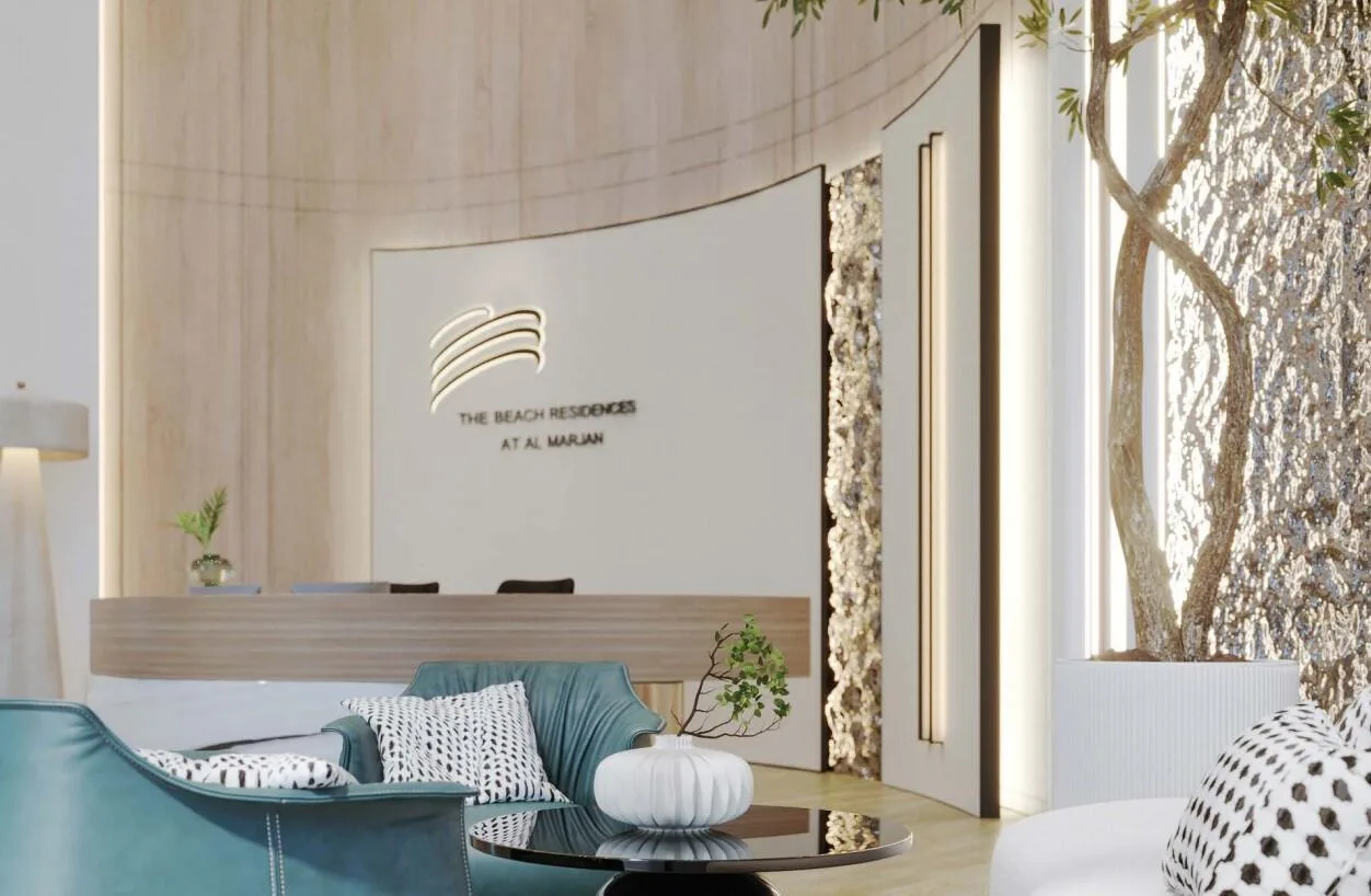 Лобби The Beach Residences: стойка с названием дома, кресла и живое дерево