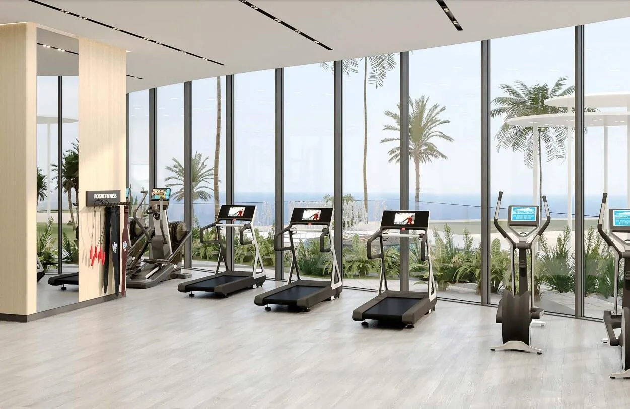Спортзал The Beach Residences с беговыми дорожками и окнами в сад