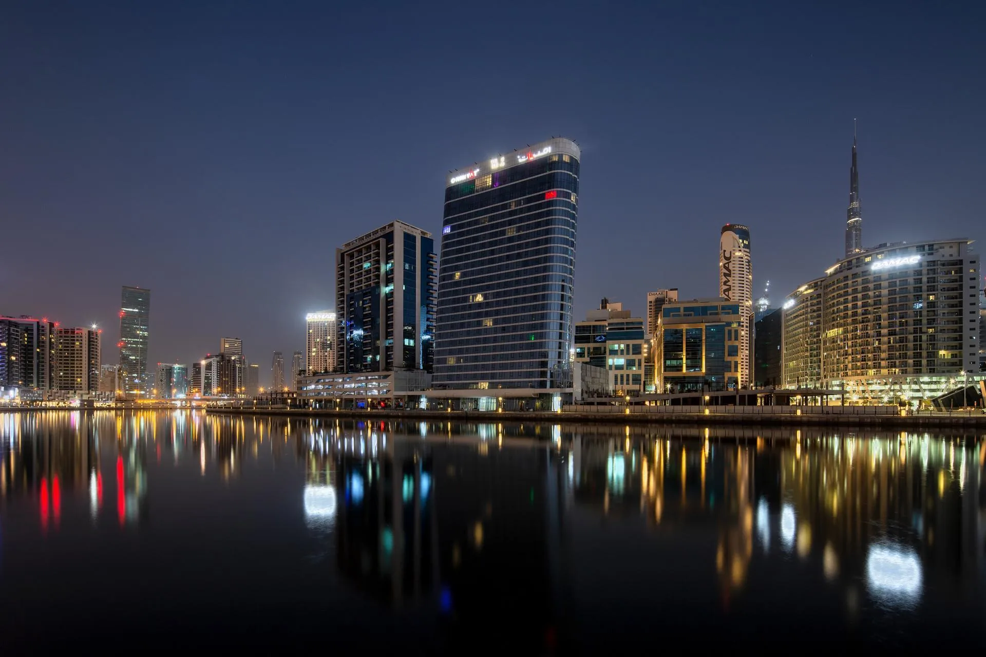 Вечерняя набережная Business Bay: огни башен в воде канала